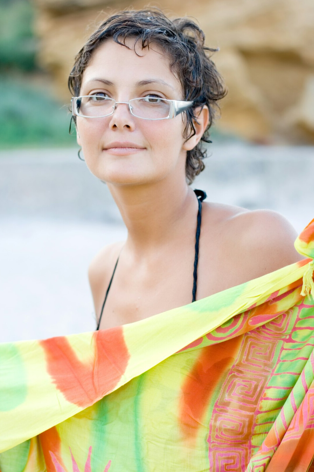 Portrait of a confident woman in her forties with short dark hair and glasses